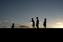 silhouettes of children playing outdoors 