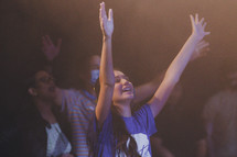 teen girl with hands raised during a worship service 