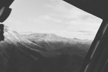 View of a mountain range from the window of an airplane.