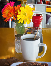 flowers on a table with coffee mug 