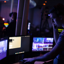 A sound technician in a sound booth during a church service.
