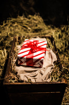 wrapped present on swaddling cloth in a manger