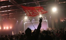 audience holding up a Jesus flag at a concert 