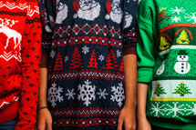 torsos in ugly Christmas sweaters  