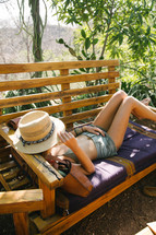 woman napping on a rattan chair 