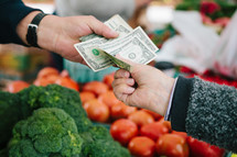paying for vegetables at a farmers market 
