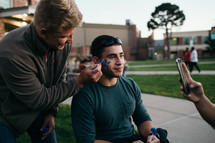 men face painting at a festival 
