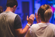 hands raised in worship at a worship service 