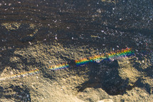 rainbow drawn in chalk on a rock 