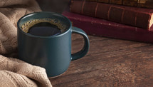 coffee cup and sweater with books 
