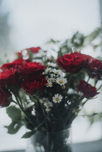 red roses and daises in a vase 