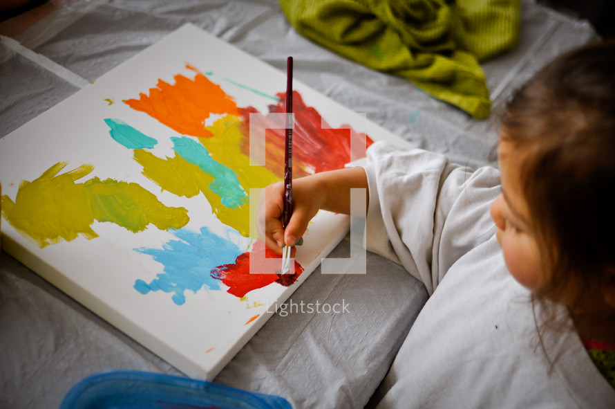 a child painting on a canvas 