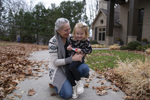 Child and grandmother on sidewalk in the fall