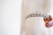 a woman holding tiara 