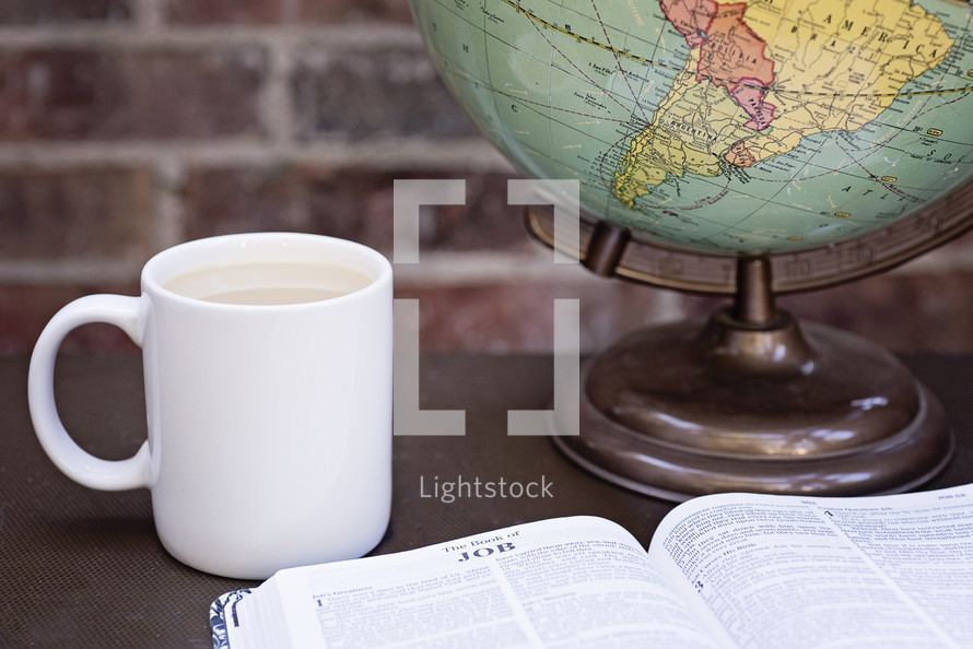 coffee mug, open Bible, and globe 