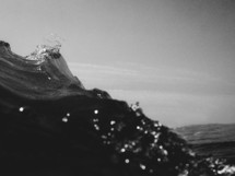 A black and white image of a wave as it passes by the camera.