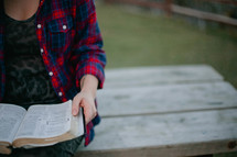A woman reading a Bible outdoors 