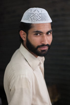 A muslim man wearing a prayer cap 