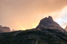 sun rising behind mountain peaks 