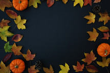 fall leaves and pumpkins on a black background 