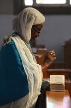 An elderly Ethiopian Orthodox woman in prayer 