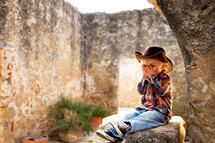 boy sitting on rock in stone building
