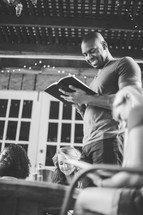 man reading a Bible to a group at a Bible study 