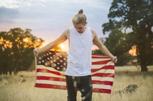 a man holding an American flag behind his back 