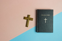 Bible and cross on a blue and pink background 