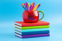 apple mug on a stack of school books 