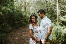 expecting couple standing on a path 