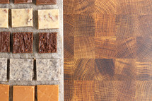 Chocolate fudge dessert squares on stone board on wood table