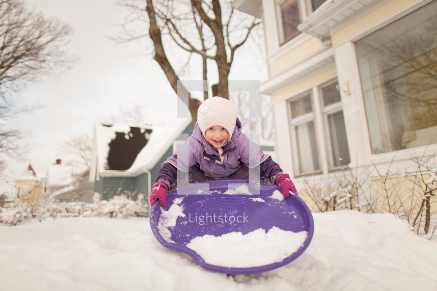 a child sledding in the snow 