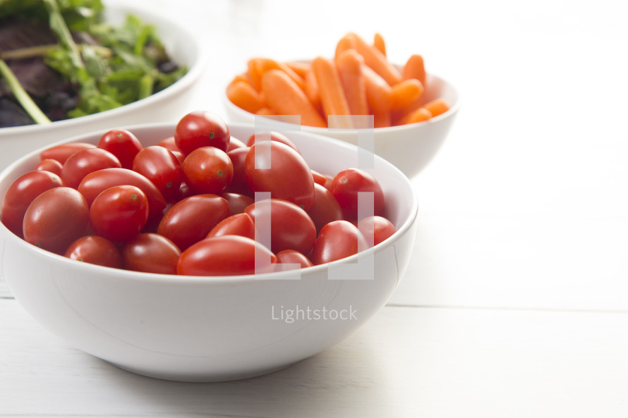 bowl of cherry tomatoes, carrots, and leafy greens 