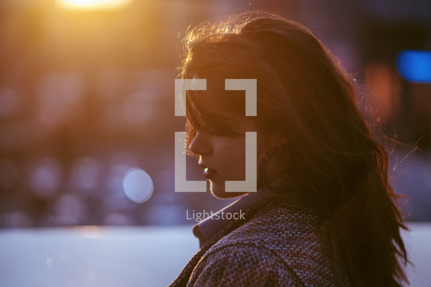 side profile of a young woman at sunset 
