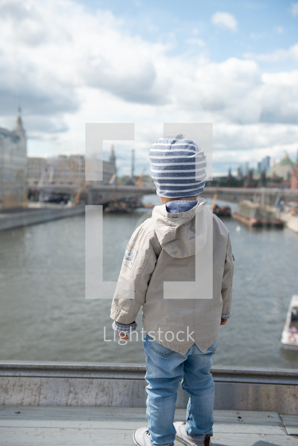 boy looking out at a river 