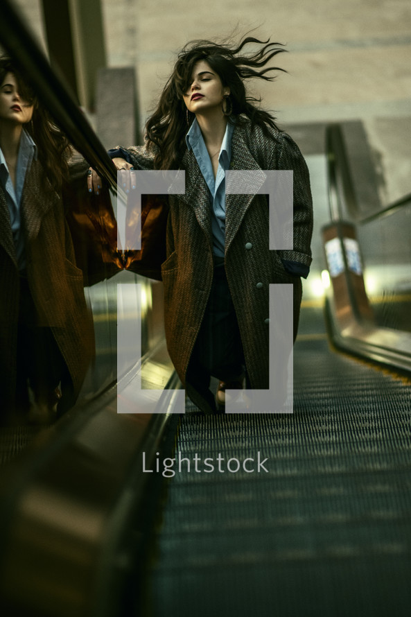 a woman in a trench coat walking in a city 
