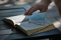 Protective - A Medical Respiratory Mask On Holy Bible at Sunset