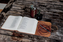 open leather bound Bible and potted cactus 
