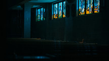 stained glass windows in a dark church 