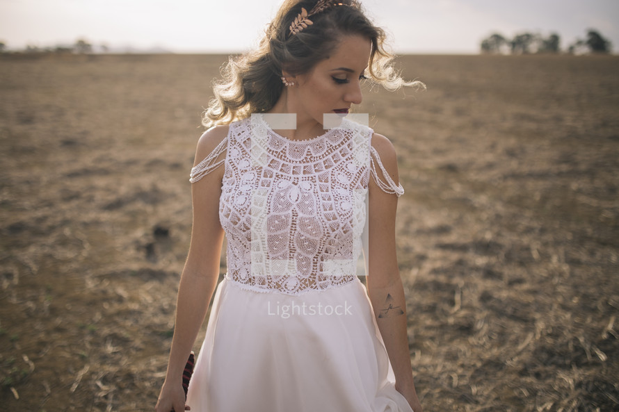 a fall bride standing in a horse pasture 