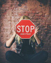 a woman holding a stop and prat sign over her face 