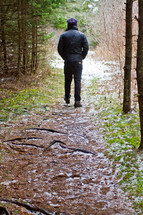 Walking on a dirt trail through the forest after the snowfall.
