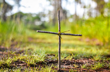 cross made from sticks and twine in the ground