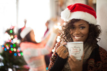 A woman wearing a santa hat and holding a cup of coffee