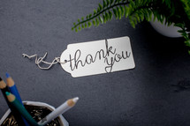 words thank you on a gift tag on a desk 
