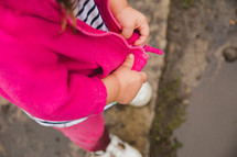 a toddler girl zipping a jacket 