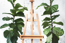 an empty easel and tropical plants 