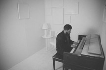 man playing a piano in a white room 