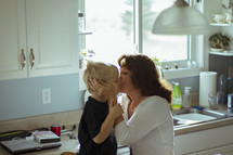 Grandson being kissed by grandmother.